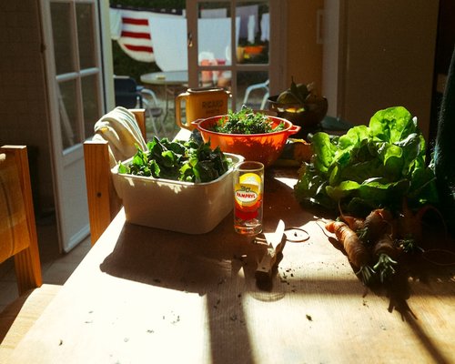Fresh vegetables, whole grain bread, and a glass of water on a wooden table