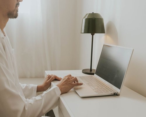 Man working comfortably on a laptop at a home office desk