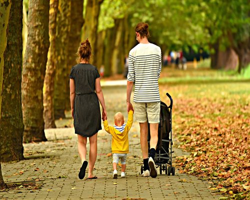Family walking together in a green city park